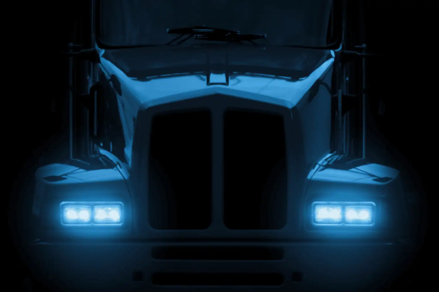 Front view of parked OTR freight truck at night