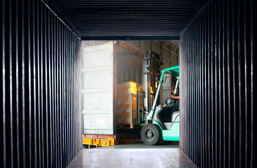 An inside view of a shipping container parked at a freight facility loading dock