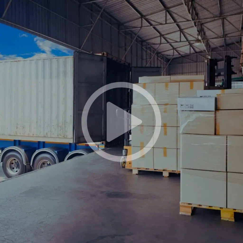 Shipping container with pallets of boxed goods inside a warehouse, showcasing logistics and supply chain solutions.